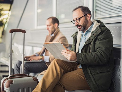 Two men with luggage reading